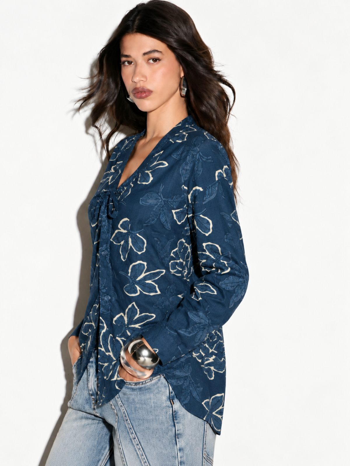 Side view of Leher blue floral shirt on model showing long sleeves and curved hem