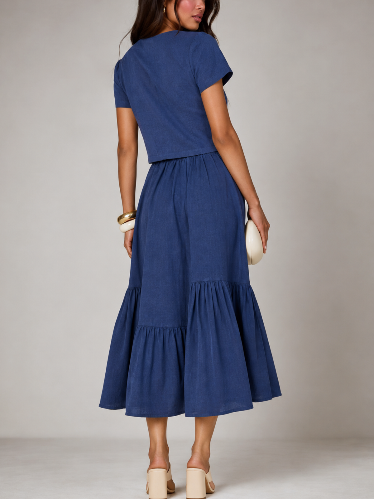 Back view of CHLOE blue linen crop top and flared tiered midi skirt