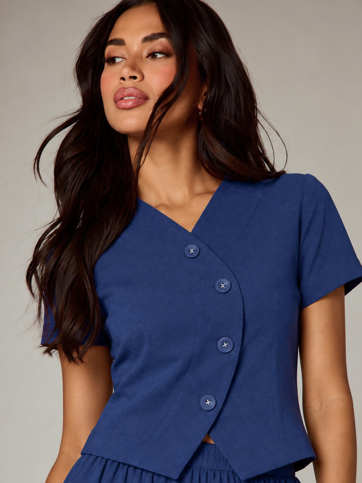 Close-up of CHLOE blue linen crop top with V-neck and curved asymmetric button front