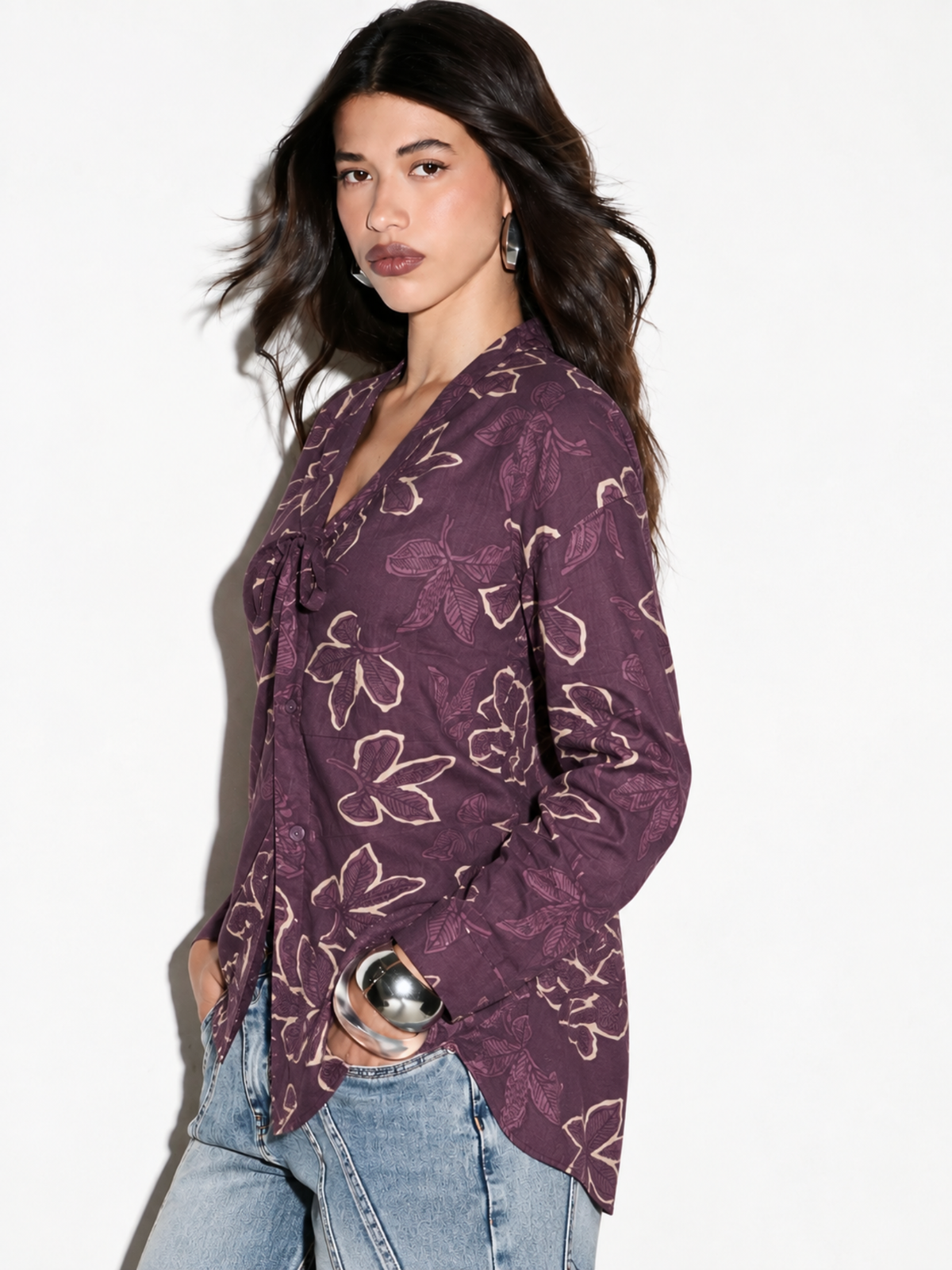 Side view of Leher mauve floral shirt on model showing long sleeves and curved hem